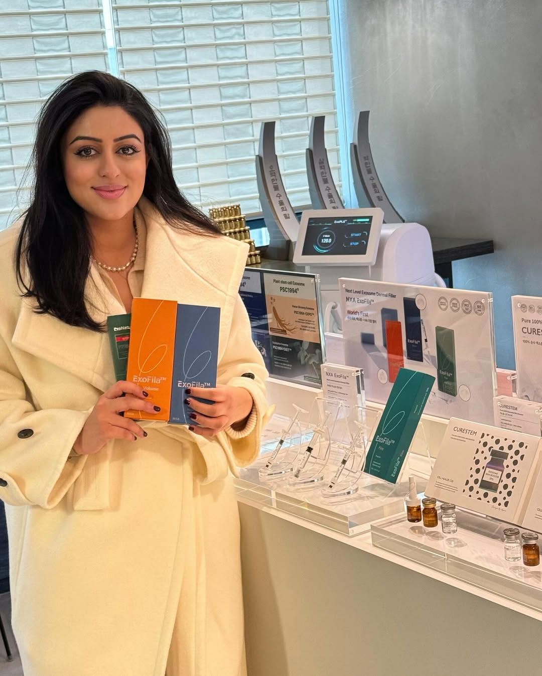 Sana Kaisar, founder of Aesthetic Skin Cells, holding ExoFila exosome products at the clinic.